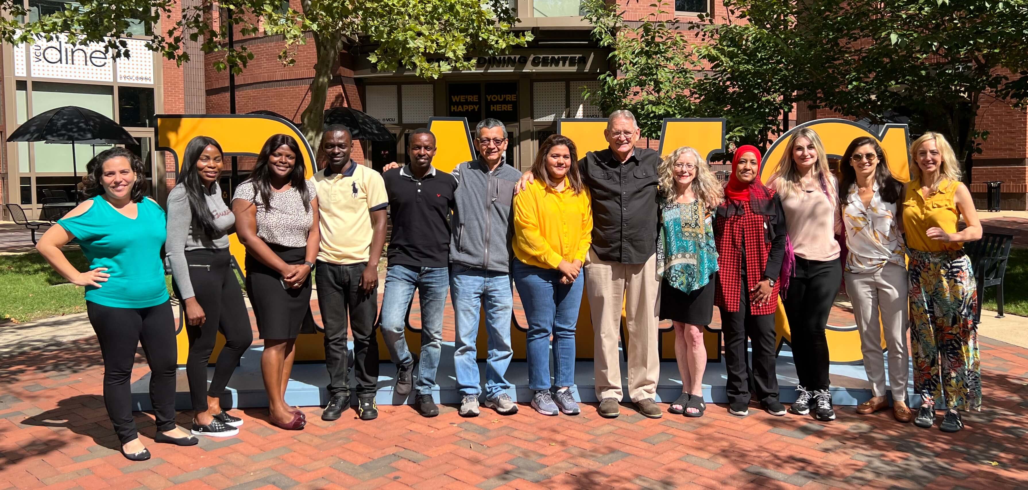 A group of Humphrey fellows pose in front of a VCU sign